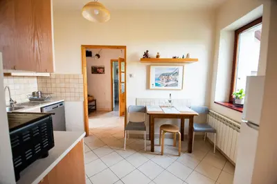 a kitchen with a table and chairs in a room at Cracow Family House in Kraków