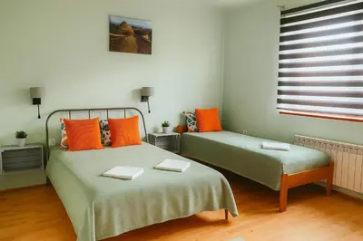 two beds in a room with orange and green at Cracow Family House in Kraków