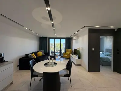 a living room with a table and a couch at Beautiful apartment with air conditioning, balcony and underground garage in Kraków
