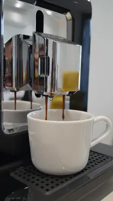 a coffee maker is making a cup of coffee at Beautiful apartment with air conditioning, balcony and underground garage in Kraków