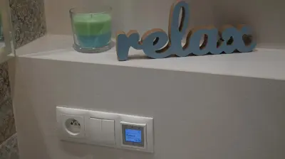 a shelf with a glass of green liquid and a candle at Beautiful apartment with air conditioning, balcony and underground garage in Kraków