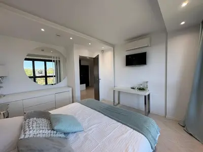 a bedroom with a large bed and a mirror at Beautiful apartment with air conditioning, balcony and underground garage in Kraków