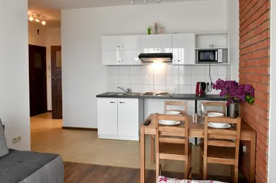 a kitchen with white cabinets and a table and chairs at ANGELS A in Zator