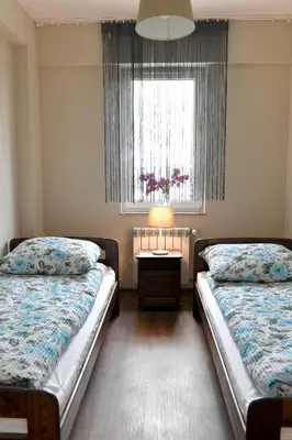 a bedroom with two beds and a window and a table at ANGELS A in Zator