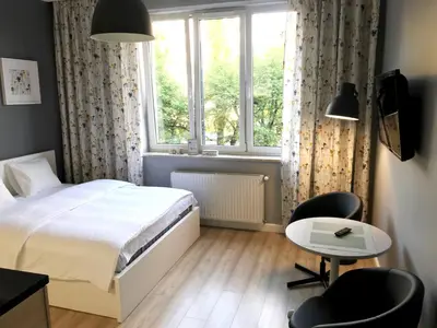 a bedroom with a bed and a table and a window at Apartment II GrayFor2 Old Town Kraków in Kraków