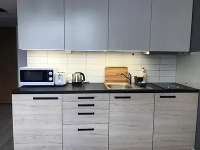 a kitchen with white cabinets and a microwave and a sink at Apartment II GrayFor2 Old Town Kraków in Kraków