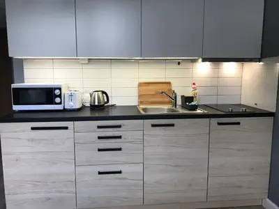 a kitchen with white cabinets and a microwave and a sink at Apartment II GrayFor2 Old Town Kraków in Kraków