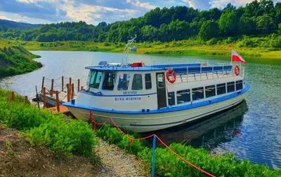 a boat is docked on a river at Tarnawianka Apart, jacuzzi, sauna, bilard in Tarnawa Górna