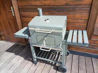 a barbecue grill on a cart on a deck at Tarnawianka Apart, jacuzzi, sauna, bilard in Tarnawa Górna
