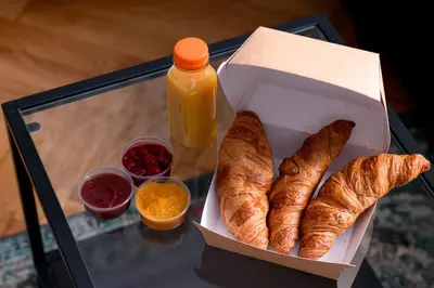 a box of croissants and a bottle of orange juice at Native Apartments Rajska 3 in Kraków