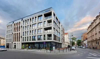 a large white building on the corner of a street at Native Apartments Rajska 3 in Kraków