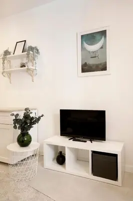 a white living room with a flat screen tv at Cozy Studio perfect for couples, Cracow Old Town in Kraków