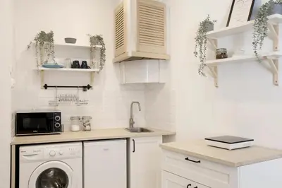 a kitchen with white cabinets and a washing machine at Cozy Studio perfect for couples, Cracow Old Town in Kraków