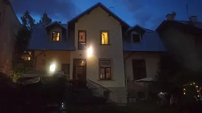 a large white house with its lights on at night at Willa Retro Hostel & Garden in Kraków