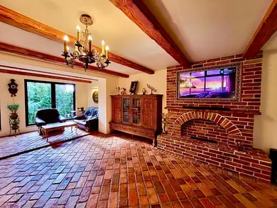 a living room with a brick fireplace and a tv at Cracow. Villa Cherubin Garden in Kraków