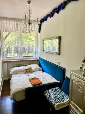 a bedroom with a bed with a blue headboard and a window at Cracow. Villa Cherubin Garden in Kraków