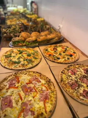 a bunch of pizzas sitting on a table at Greg&Tom Beer House Hostel in Kraków