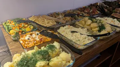 a table topped with trays of different types of food at Greg&Tom Beer House Hostel in Kraków