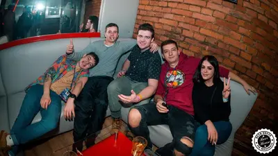 a group of people sitting on a couch giving thumbs up at Greg&Tom Beer House Hostel in Kraków