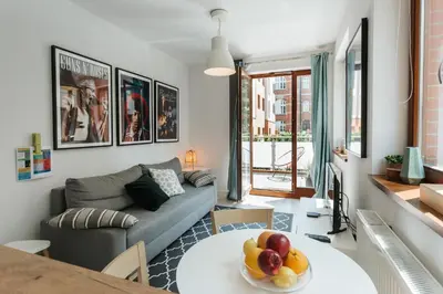 a living room with a couch and a table with a bowl of fruit at Harmo Old Town with Spacious Sunny Terrace in Kraków