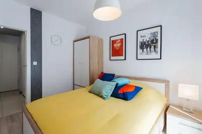 a bedroom with a yellow bed in a room at Harmo Old Town with Spacious Sunny Terrace in Kraków