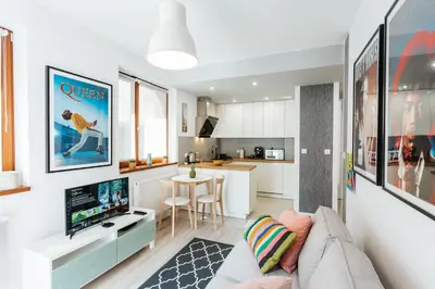 a living room with a couch and a kitchen at Harmo Old Town with Spacious Sunny Terrace in Kraków