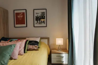 a bedroom with two beds and two pictures on the wall at Harmo Old Town with Spacious Sunny Terrace in Kraków