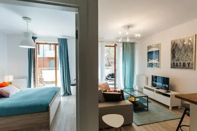 a bedroom with a bed and a living room at Nica Old Town Free Parking Spacious Sunny Terrace in Kraków