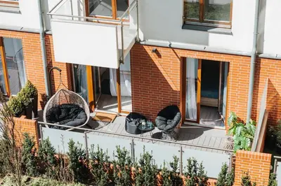 a balcony of a building with chairs and plants at Nica Old Town Free Parking Spacious Sunny Terrace in Kraków