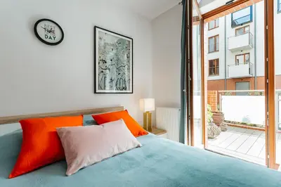 a bedroom with a bed and a clock on the wall at Nica Old Town Free Parking Spacious Sunny Terrace in Kraków