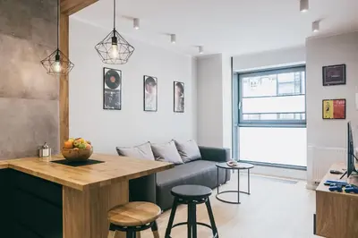 a living room with a table and a couch at Harmonica Old Town with Free Parking in Kraków