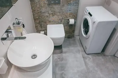 a bathroom with a toilet and a washing machine at Harmonica Old Town with Free Parking in Kraków
