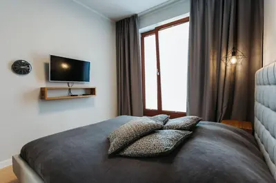 a bedroom with a bed with pillows and a television at Harmonica Old Town with Free Parking in Kraków