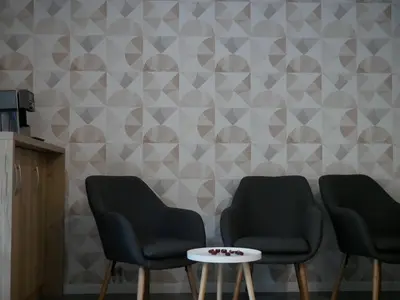 a waiting room with two chairs and a table at Ermine Suites in Kraków