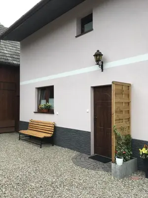 a bench sitting on the side of a house at Apartament 212 in Klikuszowa