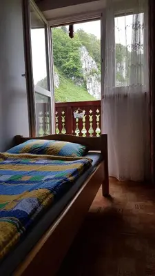 a bedroom with a bed and a window with a view at Gospodarstwo Agroturystyczne Dolina Zachwytu in Sułoszowa