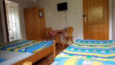 a bedroom with two beds and a table and chairs at Gospodarstwo Agroturystyczne Dolina Zachwytu in Sułoszowa