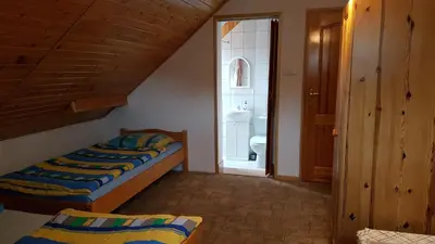 a small bedroom with two beds and a bathroom at Gospodarstwo Agroturystyczne Dolina Zachwytu in Sułoszowa