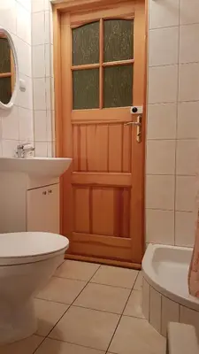 a bathroom with a toilet and a sink and a door at Gospodarstwo Agroturystyczne Dolina Zachwytu in Sułoszowa