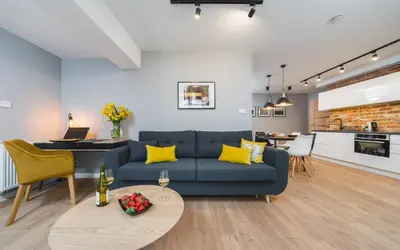 a living room with a blue couch and a table at Barbakan Residence Old Town in Kraków