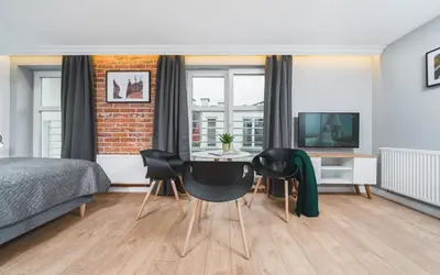a bedroom with a bed and a table and chairs at Barbakan Residence Old Town in Kraków