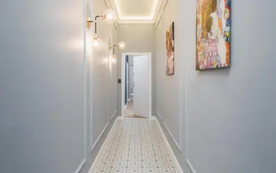 a hallway with white walls and a white tile floor at Art of Serenity in Kraków