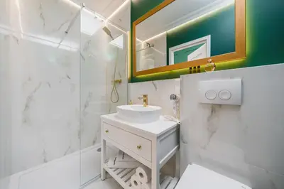 a white bathroom with a sink and a mirror at Art of Serenity in Kraków