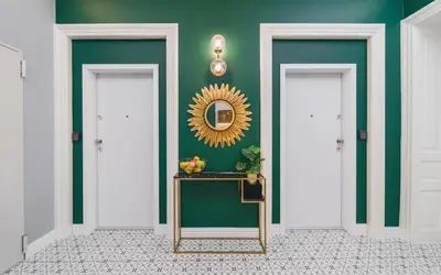 a hallway with green walls and a mirror and a table at Art of Serenity in Kraków