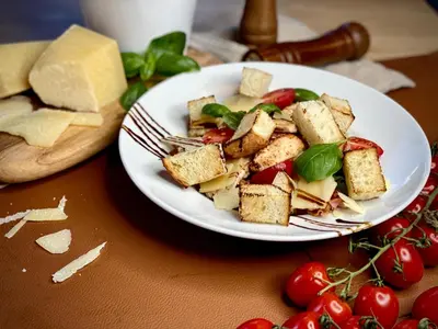 a plate of food on a table with cheese and tomatoes at Hotel CONRAD Comfort in Kraków