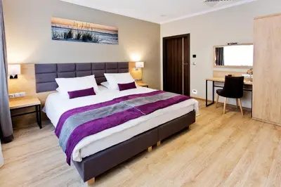 a bedroom with a large bed and a desk at Hotel CONRAD Comfort in Kraków