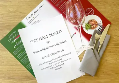 a dinner menu with a wine glass and a plate of food at Hotel CONRAD Comfort in Kraków