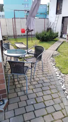 three chairs and a table and an umbrella on a patio at Queens house in Oświęcim