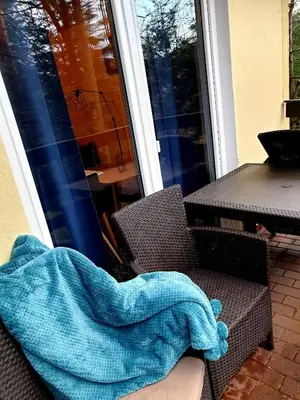 a blanket sitting on a chair on a patio at Osada Babiogórska - domki gościnne in Zawoja