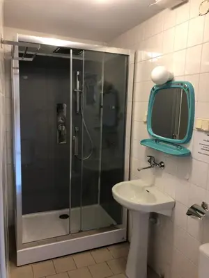 a bathroom with a shower and a sink and a mirror at Osada Babiogórska - domki gościnne in Zawoja